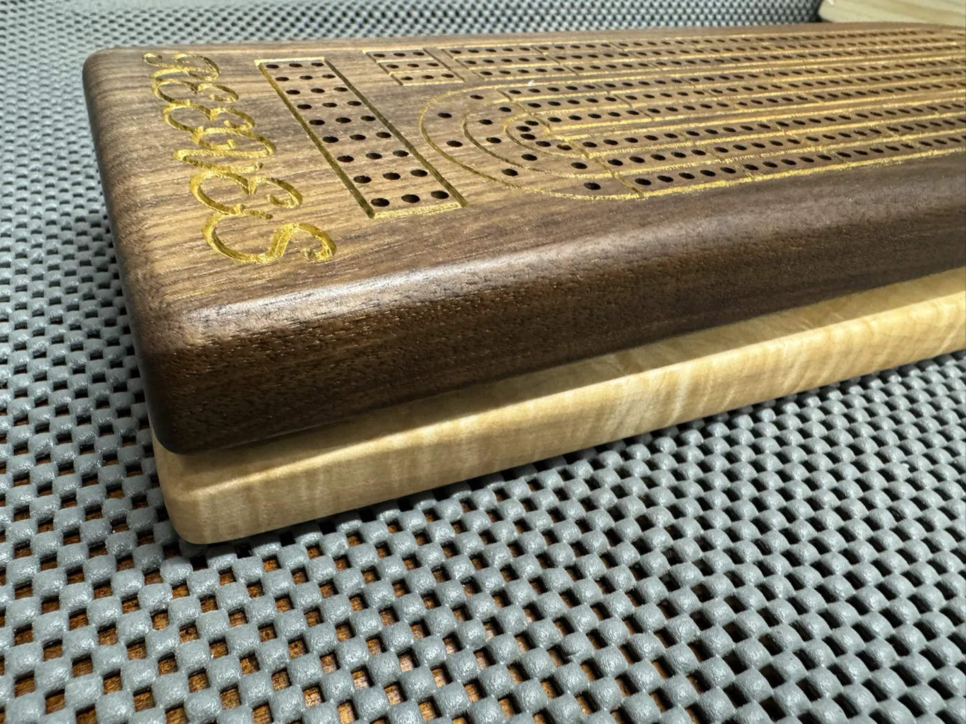 Custom walnut cribbage board with a personalized name and tiger maple base