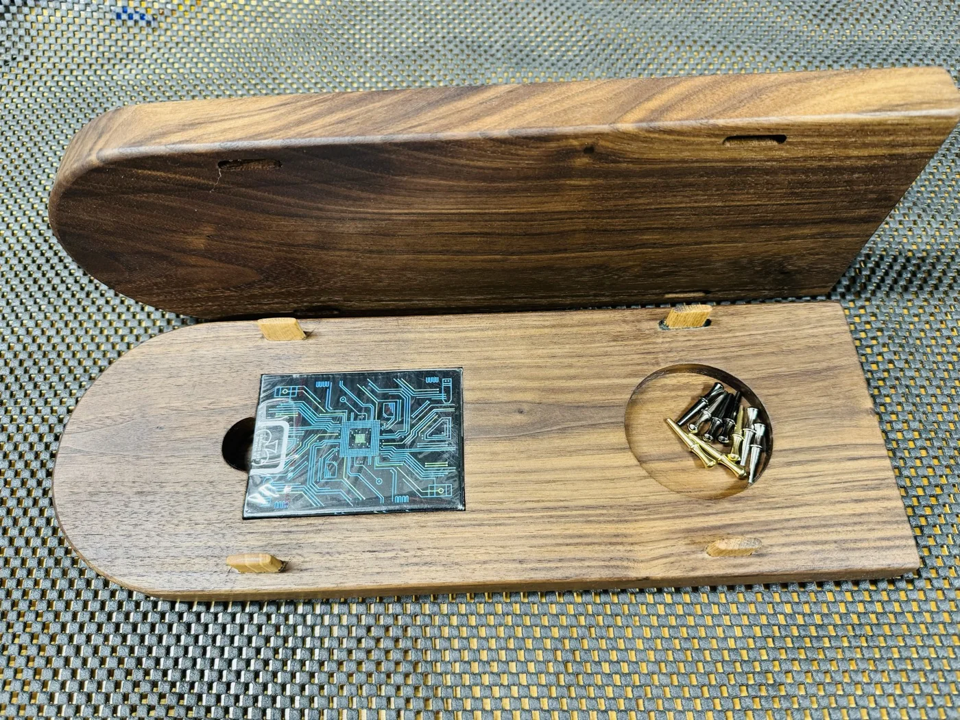 Open wooden cribbage board showing a deck of cards and pegs in fitted storage