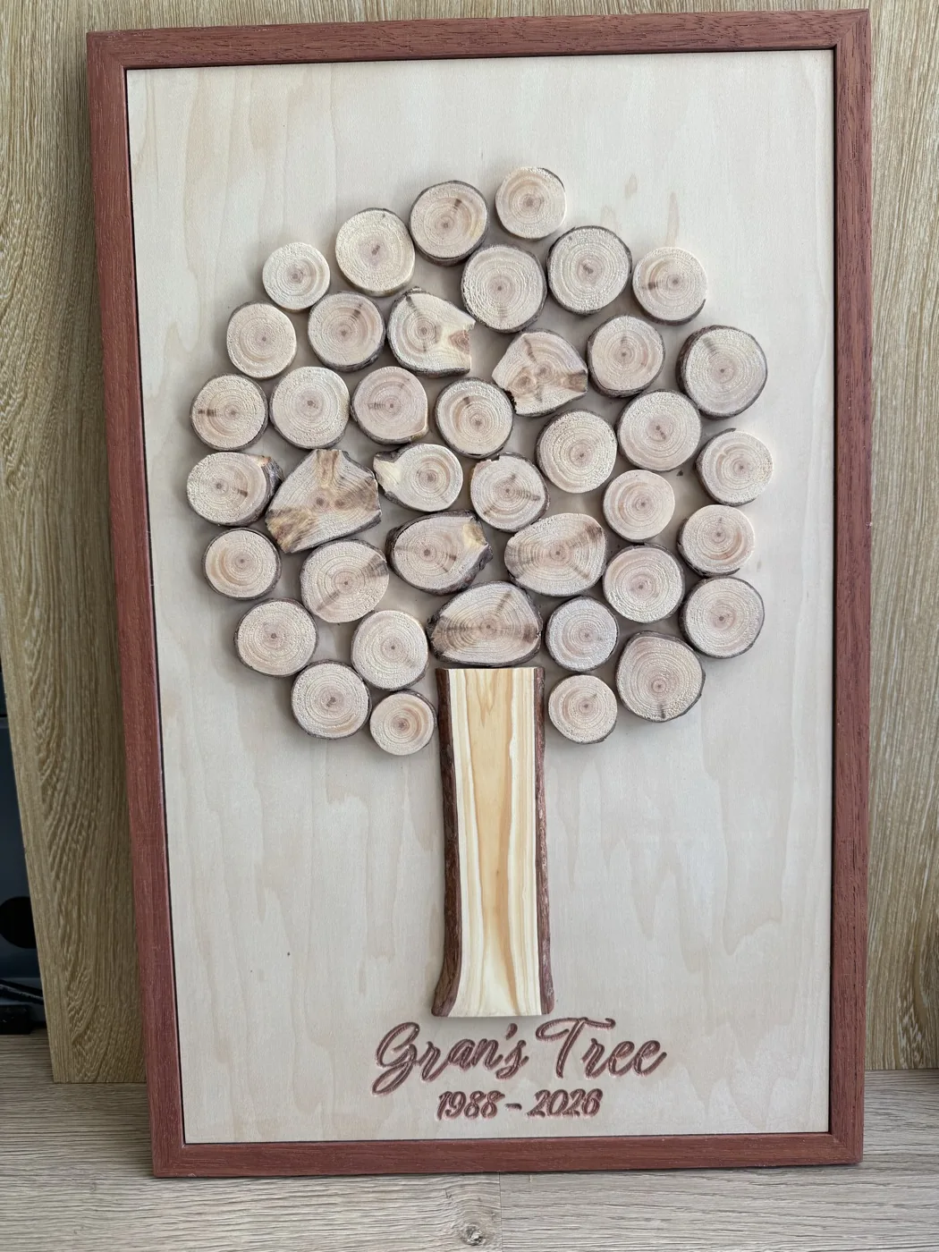 Framed tree made from pine branch slices with an engraved family dedication